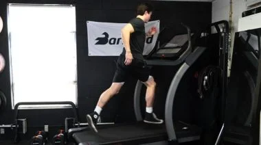 A person running on a treadmill in the BarBend gym.