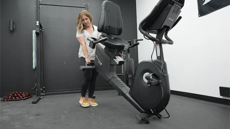 sole-lcr-exercise-bike-full-view-moving-bike Our tester moving the Sole LCR Exercise Bike into position for a workout