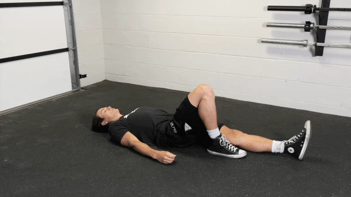 A person doing the single-leg glute bridge.