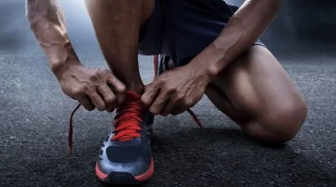 A person fixing their shoelace.