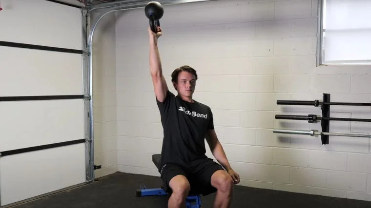 A person performing the bottoms-up kettlebell press.