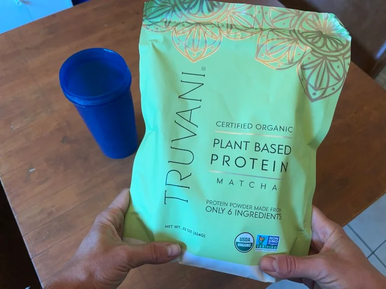 Our tester holds a bag of Truvani Plant-Based Protein Powder.