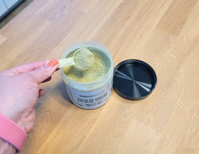 Person holding a scoop of Field of Greens Raw