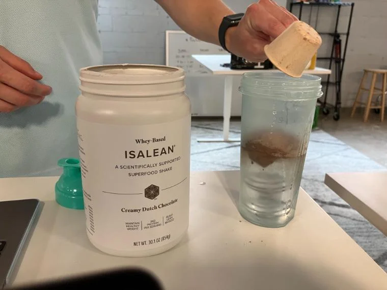 Our tester dumping a scoop of Isagenix IsaLean Shake.