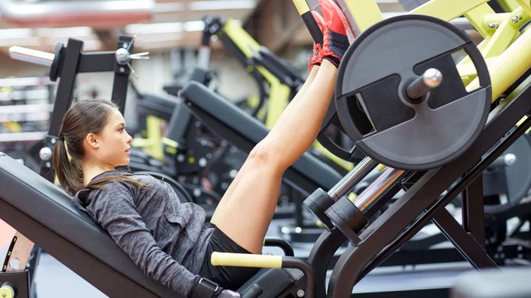 A person working out on a leg press machine.