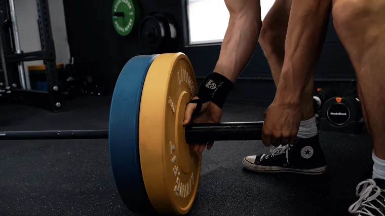 Jake Loading the Living.Fit Weight Plates on a Barbell