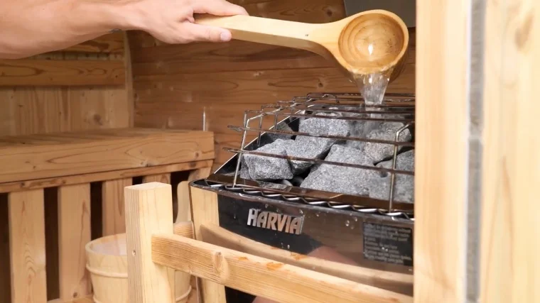 Pouring Water on the Redwood Outdoors Extra-Wide Thermowood Barrel Sauna Heater