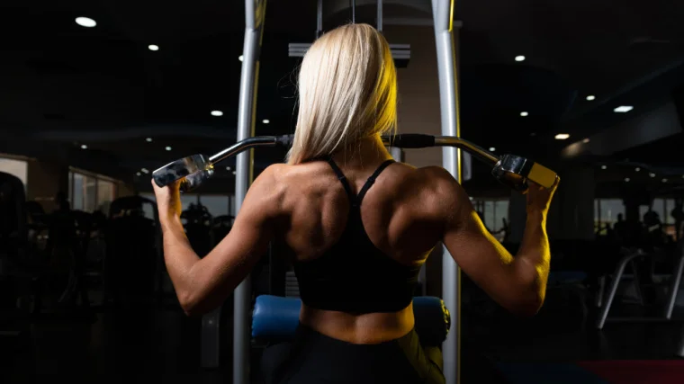 Back view of a fit person working out in the gym.