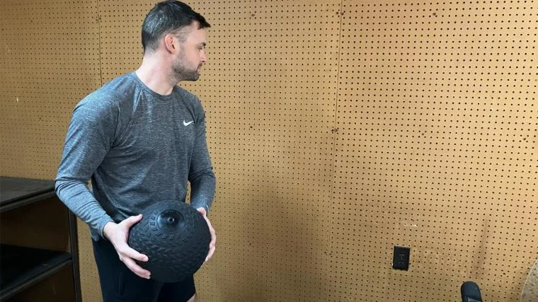 BarBend reviews writer Matt Cummings performing a wall toss with the Titan Fitness Slam Ball.