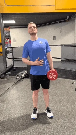 A person performing the dumbbell side bend exercise.