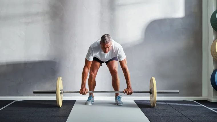 An elderly person doing the deadlift.