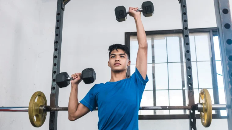 A beginner doing the alternating dumbbell press.