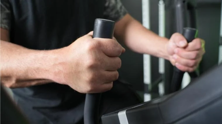 Our tester gripping the fixed handles of the ProForm Pro HIIT H14 Elliptical.