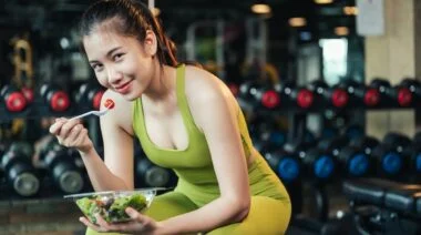 A person eating a pre-workout supplement alternative in the gym.