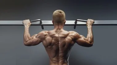 A bodybuilder doing pull-ups in the gym.