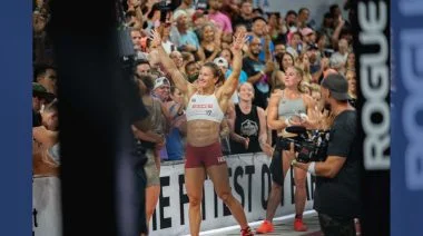 Tia-Clair Toomey-Orr raising her arms triumphantly at the CrossFit Games