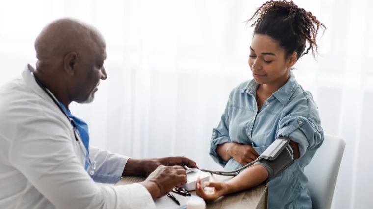 A health professional checking the blood pressure of a patient.