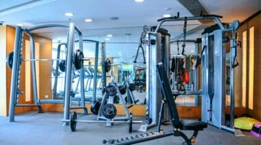 A squat stand and a power rack in the gym with other equipment.
