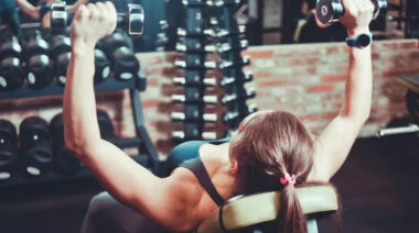A person performs an incline dumbbell bench press.