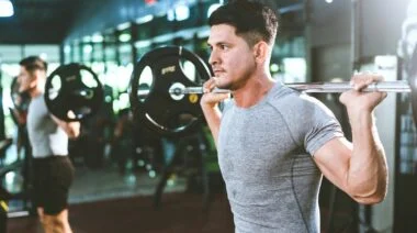 A muscular person working out with a barbell.