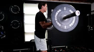 A person performing the barbell curl.