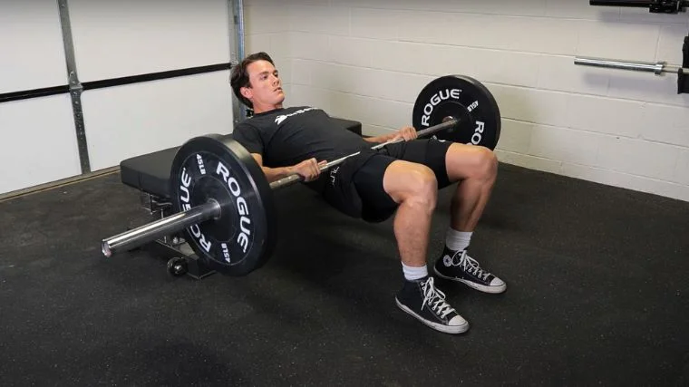 A person performing the hip thrust exercise.