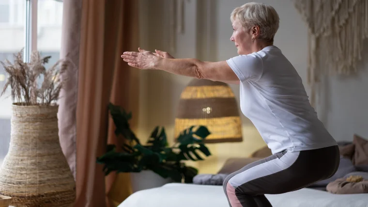 A woman performing yoga chair pose in the comforts of home..