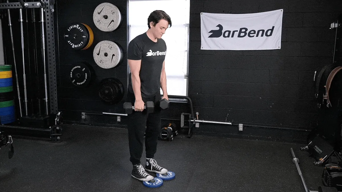 BarBend's Jake Herod performing the toe-elevated dumbbell Romanian deadlift.