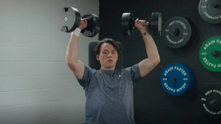 A BarBend tester trying the NÜOBELL Adjustable Dumbbells.