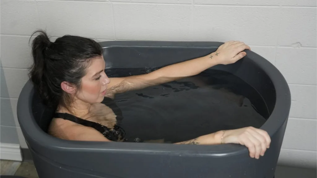 BarBend tester sitting in Nordic Wave Viking cold plunge.