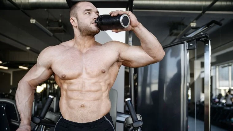 An athlete drinking protein shake in the gym.
