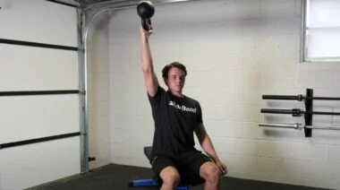 A person performing the bottoms-up kettlebell press.