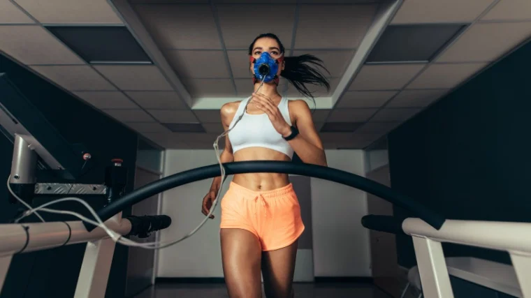 A fit person running on a treadmill with a mask.