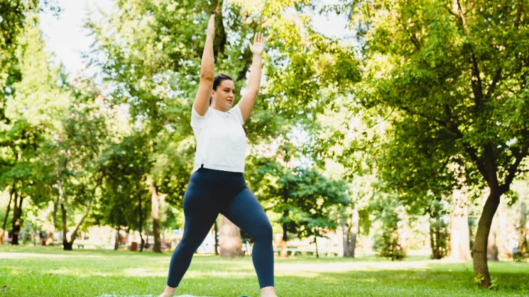 A person doing exercises on an exercise mat outdoors.