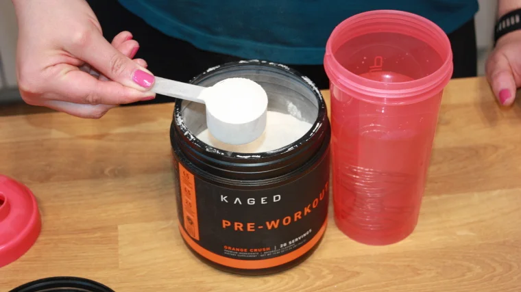 Our tester lifts a scoop of Kaged Muscle Pre-Workout