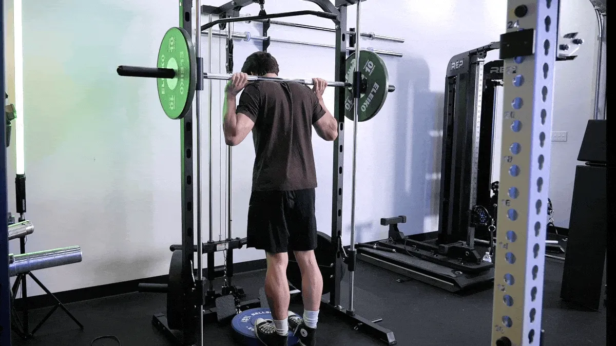 A person doing the Smith Machine calf raise.