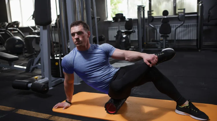 An athlete using a foam roller.