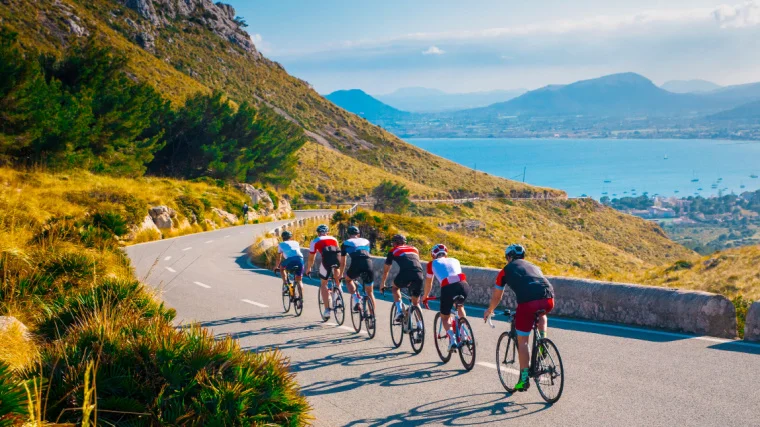 A  group of people cycling in the daytime.