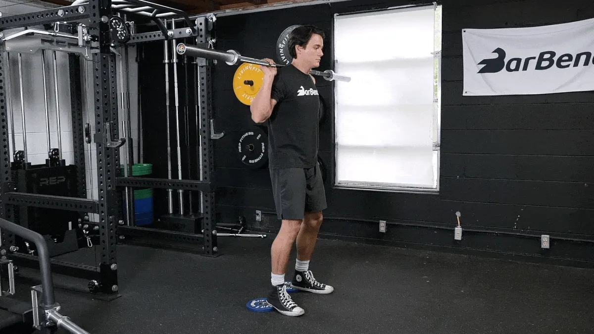 BarBend's Jake Herod performing the heel-elevated back squat exercise.