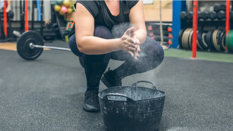 A person claps chalk onto their hands.