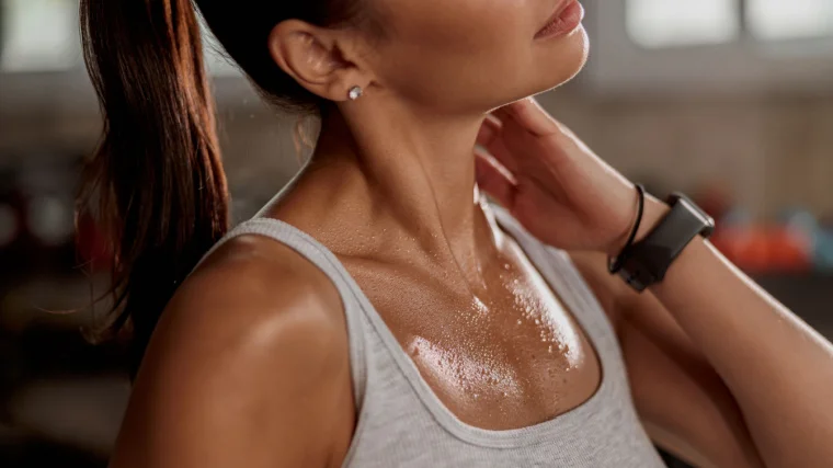 A person with smooth skin with sweat on their chest.