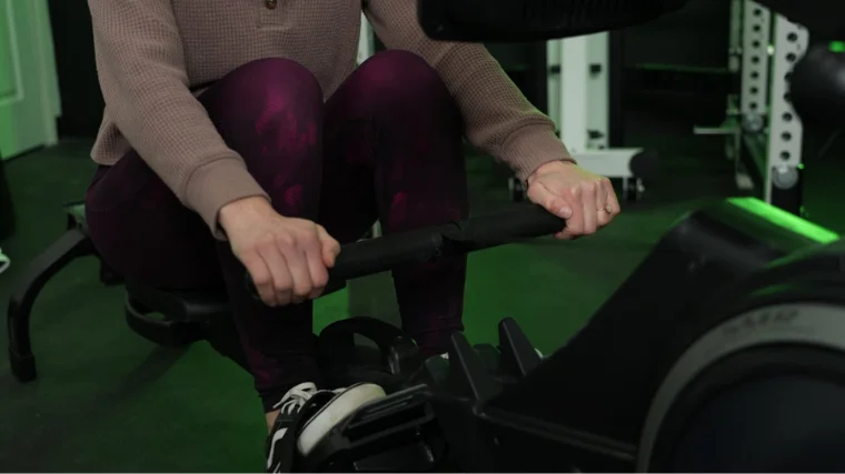 A person gripping the handles of the ProForm 750 R rowing machine.