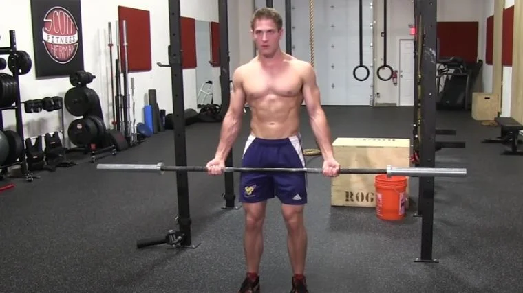 An bodybuilder starting to do drag curls.