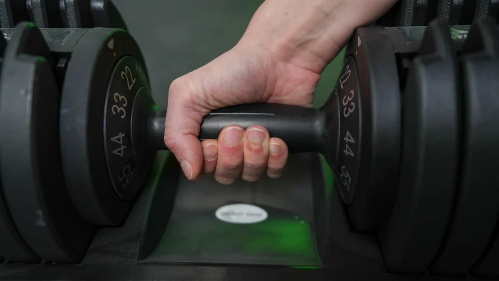 Our tester adjusting the FLYBIRD Adjustable Dumbbell.
