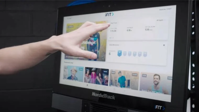 BarBend lead video reviewer Jake Herod, NASM-CPT, selecting an iFIT class on the NordicTrack S22i.