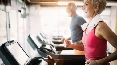 Two elderly people on treadmills.