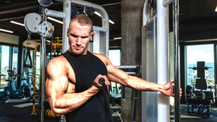 Person with large muscles working out with cables.