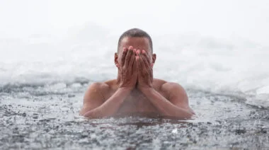 A person emerges from icy water.