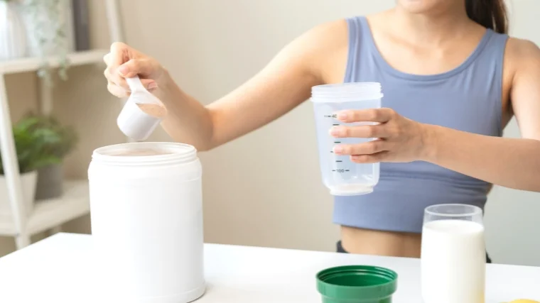A person preparing a pre-workout drink