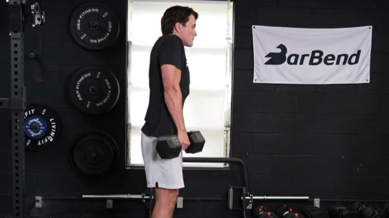 A person doing the dumbbell shrug exercise.